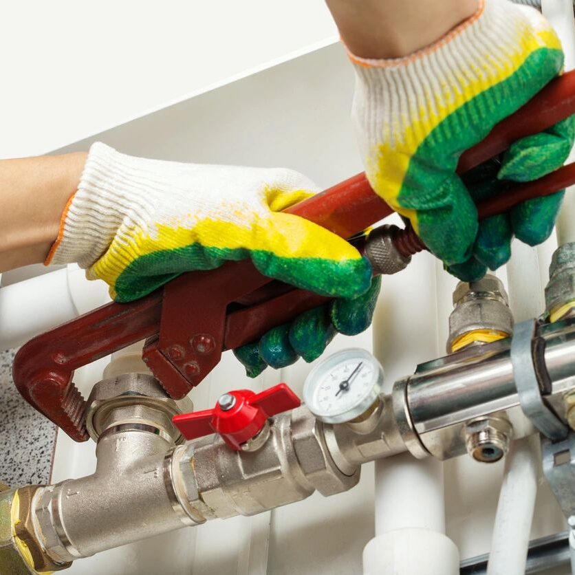 Worker hands fixing heating system Worker hands fixing heating system